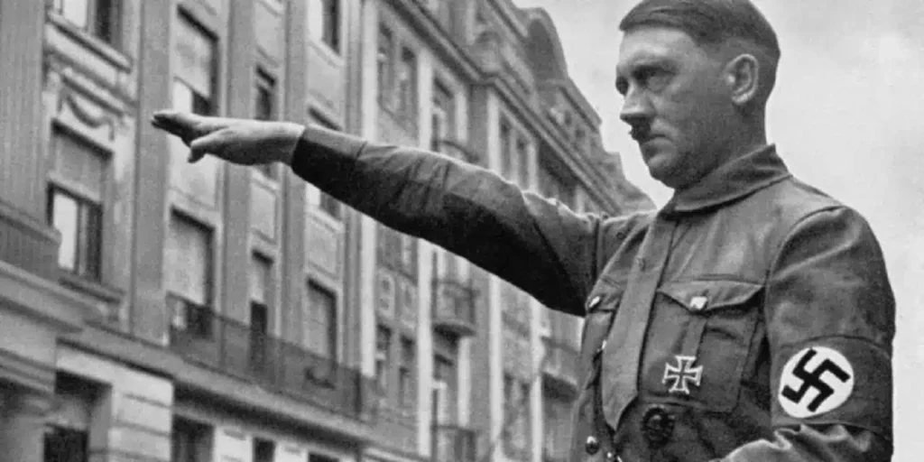 Hitler fardado com a mão batendo continência para uma multidão