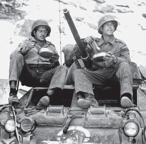 Dois soldados brasileiros comendo em cima de um M8 Greyhound em o que foi a Força Expedicionária Brasileira