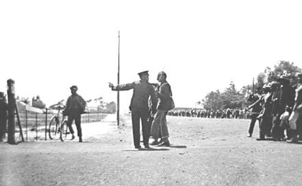 Gandhi sendo confrontado por um policial ao liderar os mineradores hindus em greve de Newcastle ao Transvaal em protesto contra o "Ato da Imigração" em 1913