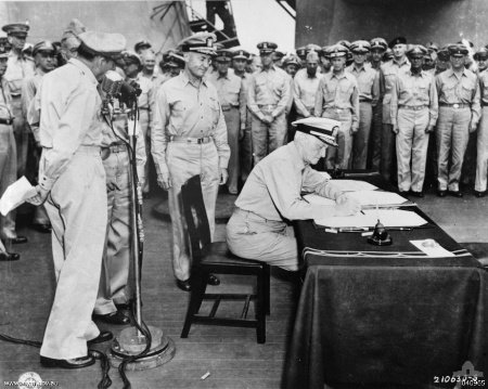 A rendição do Japão a bordo do USS Missouri na Baía de Tóquio, 2 de setembro de 1945: o almirante da frota Chester Nimitz, representando os Estados Unidos, assina o instrumento de rendição.